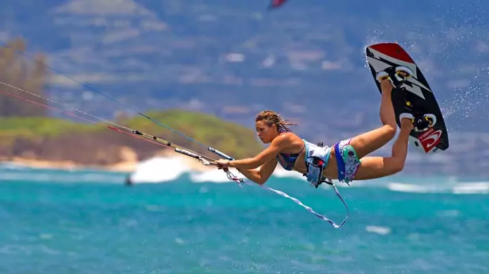Girl trick shoting on a kite surf image.